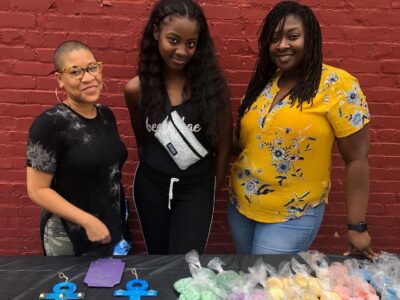 ladies at an Excellence and Ambition vending table