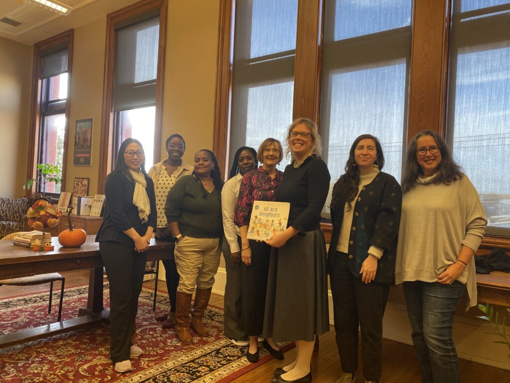 Photo of Community Law Center staff holding the book All Our Neighbors